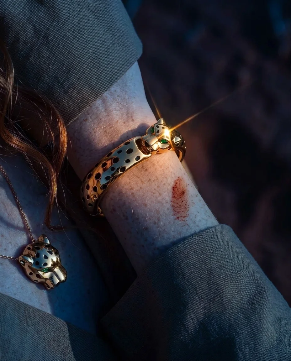 The Object — Skin, gold, a fingertip of red sand. The Panthère cuff at macro — emerald eye sharp, enamel rosettes crisp. Worn close, felt longer.